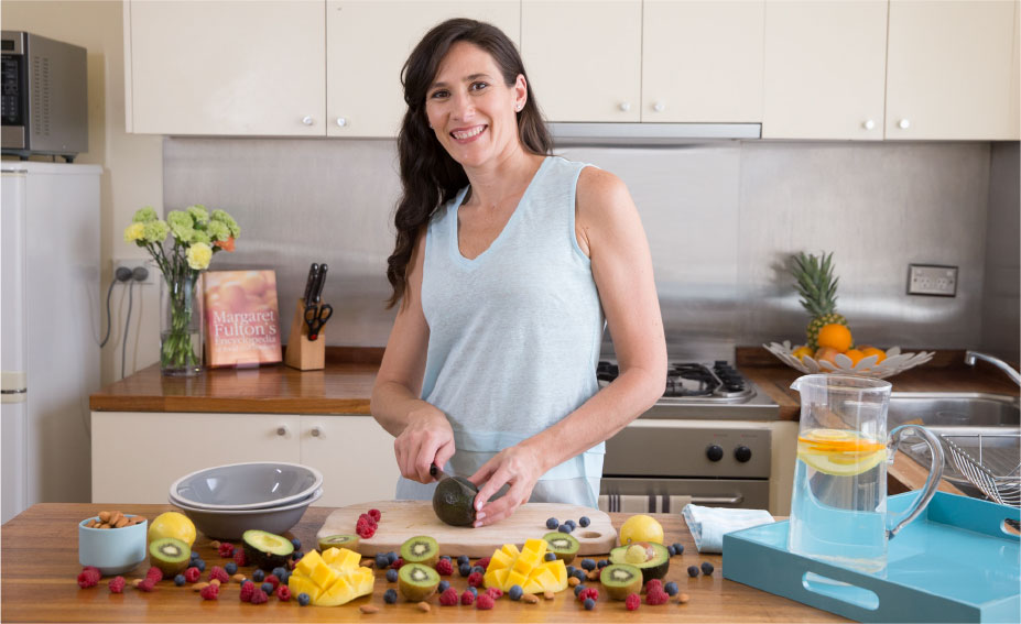 Melanie McGrice in the kitchen chopping fruit