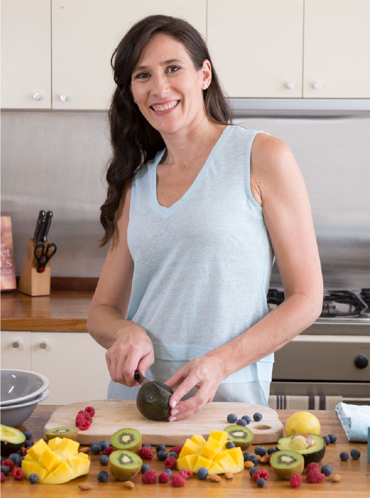 Melanie McGrice in the kitchen chopping fruit