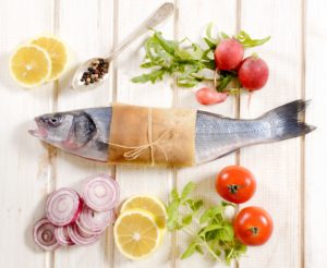 Bass fish from above on the white wooden background