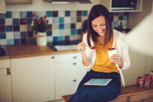 woman eating raspberries while doing an online program